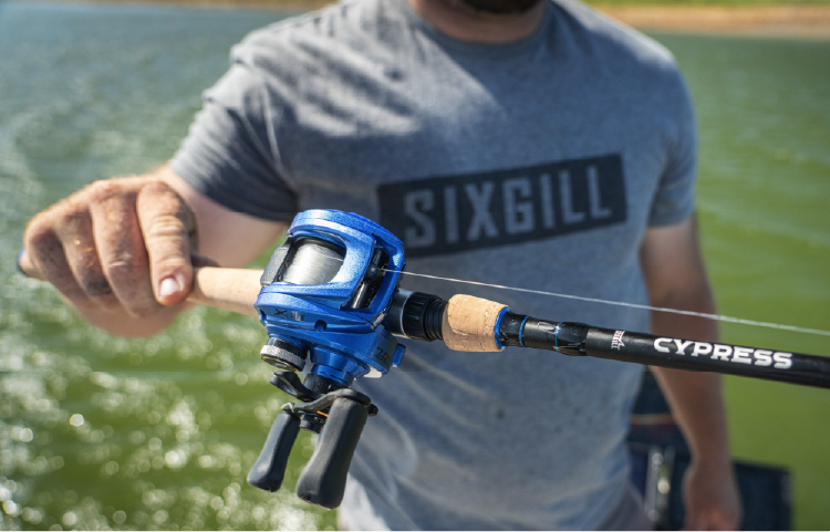 Angler holding a blue baitcasting reel on a Sixgill Cypress rod
